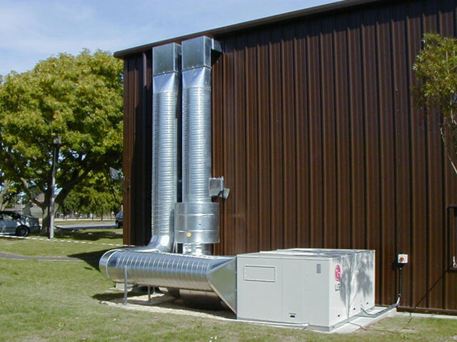 A large commercial ventilation system on the side of a warehouse