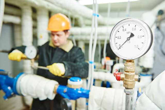 Image of a pressure valve and an engineer servicing an HVAC system