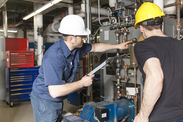 Two engineers servicing an HVAC system